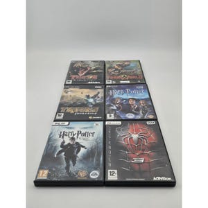 Op de afbeelding: Een verzameling pc-gamecases met titels als "Turok Evolution", "Harry Potter" en "Spider-Man". De zwarte cases tonen kleurrijke game-art en logo's. Sommige cases hebben leeftijdsclassificaties en het label "PC DVD-ROM".