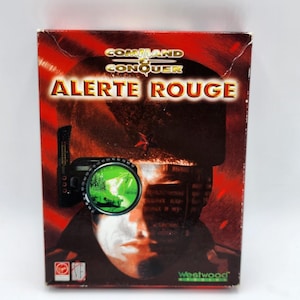 May include: A Command & Conquer: Red Alert PC game box. The box is predominantly red with the game title "ALERTE ROUGE" in large gold letters. The image features a soldier with a green scope and a red star.