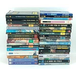 Peut inclure: Une pile de livres de poche avec des titres variés, principalement en français. Les couvertures affichent des titres de science-fiction et de fantasy. Les livres sont empilés sur un fond blanc.
