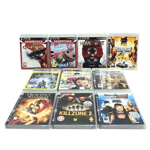 May include: A collection of PlayStation 3 video game cases. Titles include "God of War," "Little Big Planet," "Homefront," "Saints Row," "Heavenly Sword," and "Killzone 2." The cases are in clear plastic and feature colorful game art.