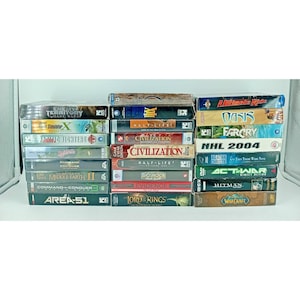 May include: A collection of PC game boxes, including titles such as "Enemy Territory", "Civilization", "Half-Life", "Far Cry", and "World of Warcraft". The boxes are stacked, displaying game titles and graphics in various colours.