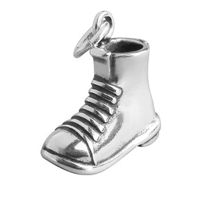 May include: A silver charm in the shape of a boot. The boot has a lace-up design and a rounded toe.