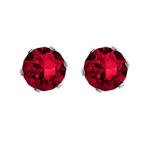 Peut inclure: Une paire de boucles d'oreilles en argent avec une pierre rouge ronde dans chaque boucle d'oreille.