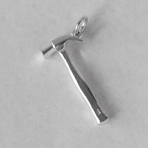 May include: Silver hammer charm pendant. The hammer has a smooth, rounded head and a textured handle.