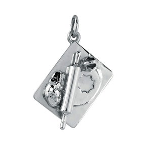 May include: Silver charm featuring a rolling pin, dough, and a cookie cutter on a baking tray.