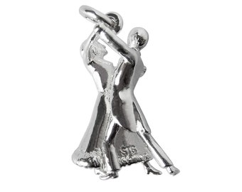 May include: A silver charm depicting a couple dancing the waltz. The man is wearing a tuxedo and the woman is wearing a long gown. The charm is perfect for adding a touch of romance to any jewelry collection.
