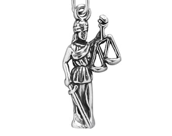 May include: A silver-colored pendant charm depicting Lady Justice. She is holding scales in one hand and a sword in the other. The charm has a loop at the top for attaching to a necklace or bracelet.