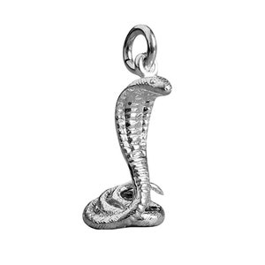 Pode incluir: Berloque de prata em forma de cobra com a capela levantada. O berloque é detalhado com escamas e tem um laço para prender a uma pulseira ou colar.