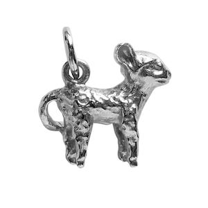 May include: A silver charm in the shape of a small, standing deer. The charm has a textured surface and a loop at the top for attaching to a bracelet or necklace.