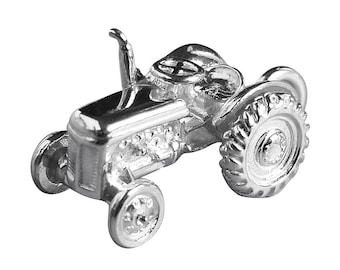 May include: A silver charm shaped like a vintage tractor. The tractor has a detailed design with a rounded bonnet and large wheels.