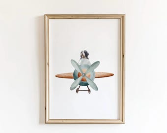 May include: A watercolor illustration of a dog flying a vintage airplane. The dog is sitting in the cockpit of the plane, which is painted in shades of blue and green. The plane has a wooden propeller and a brown wooden body. The background is white.