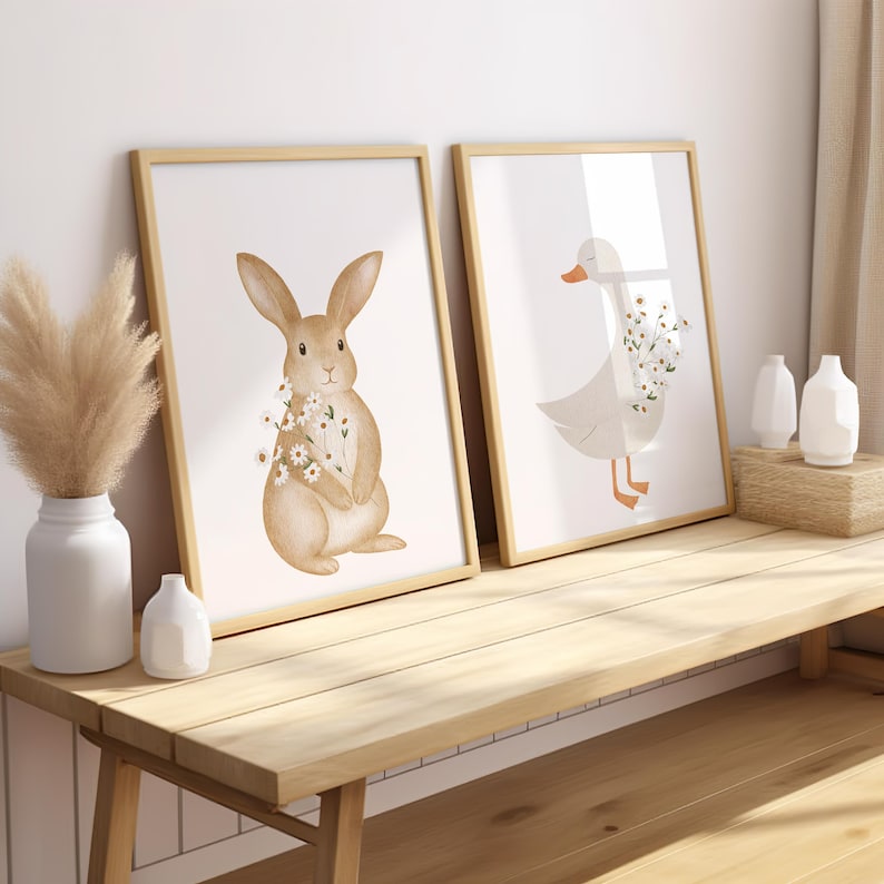 Puede incluir: Dos l&aacute;minas enmarcadas con ilustraciones en acuarela. Una representa un conejo marr&oacute;n con flores, la otra un ganso blanco con flores. Ambas en marcos de madera clara, ideales para la decoraci&oacute;n infantil.