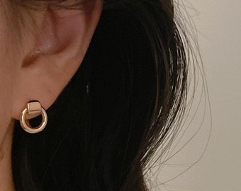 May include: Gold-toned minimalist earrings with a small square and a circle design.