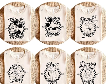 May include: Six white t-shirts with black and white images of Disney characters. The characters are Minnie Mouse, Mickey Mouse, Donald Duck, Goofy, Pluto, and Daisy Duck. Each shirt has a number from 1 to 6 printed on the top left corner.