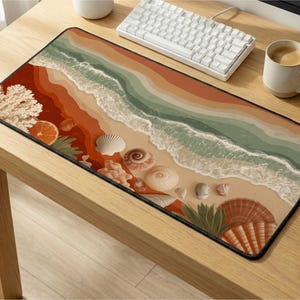 May include: A rectangular mouse pad featuring a beach scene with seashells, coral, and an orange slice. The design incorporates shades of orange, green, and beige, with a black border. A white keyboard and coffee cup are visible.