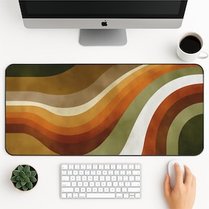 Peut inclure: Tapis de bureau rectangulaire avec un motif rétro ondulé dans des tons de marron, orange et vert. Le tapis est posé sur un bureau blanc, avec un clavier, une souris et une tasse de café visibles.