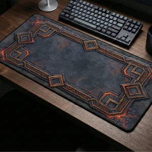May include: A rectangular desk mat featuring a dark, weathered stone-like texture in the center, surrounded by an intricate, raised-looking border of bronze-colored geometric patterns and glowing orange cracks resembling molten lava.