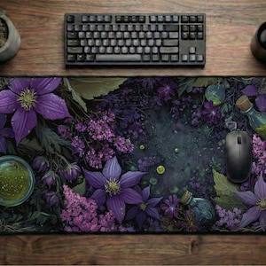 May include: A rectangular mouse pad featuring a floral design with purple flowers and green accents. A black computer mouse, keyboard, and a mug are on a wooden surface. A small potted plant is also visible.