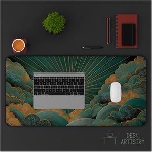 May include: A rectangular desk mat featuring a dark green and gold sunburst pattern with stylized cloud motifs. A silver laptop and a white computer mouse are placed on the mat. The design includes intricate textures and radiating lines.