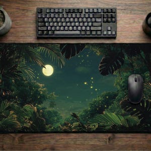 Può includere: Tappetino per mouse rettangolare con una scena della giungla con luna piena, rigoglioso fogliame verde e un cielo stellato. Un mouse per computer nero, una tastiera e una tazza sono su una superficie di legno.
