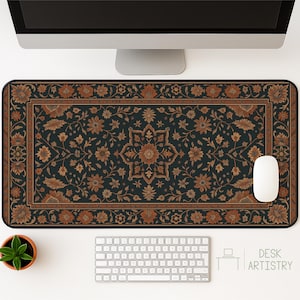 Pode incluir: Tapete de mesa retangular com fundo azul escuro e um padrão floral detalhado em tons de castanho e dourado. O tapete apresenta um design de medalhão central e uma borda decorativa. Um rato e um teclado brancos também são visíveis.