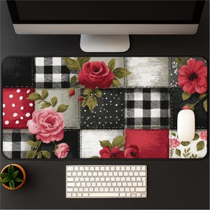 May include: A decorative mouse pad with a patchwork design featuring red roses, red polka dots, and black and white checkered patterns. A white computer mouse rests on the pad, with a keyboard and monitor in the background.