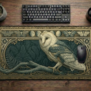 Könnte beinhalten: Eine rechteckige Schreibtischunterlage mit einer zentralen Illustration einer Schleiereule auf einem Ast. Das Design zeigt einen dunkel-türkisfarbenen Hintergrund mit Farnmustern, umrahmt von einer goldenen Bordüre mit Motten- und Mondphasen.