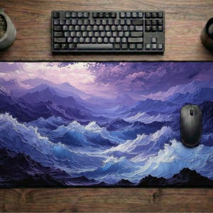 May include: A rectangular mouse mat with a dramatic ocean wave design in shades of blue and purple. A black computer mouse sits on the mat, with a black keyboard above. A small potted plant and a mug are also on the wooden surface.