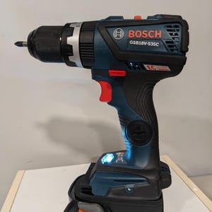 Puede incluir: Un taladro inal&aacute;mbrico azul y negro con una bater&iacute;a negra y naranja. El taladro tiene el logotipo de Bosch y el n&uacute;mero de modelo GSB18V-535C. La bater&iacute;a tiene el texto "HYPER LI Lithium Ion 18V".