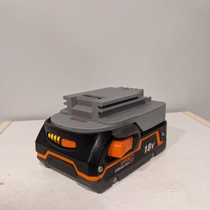 Pu&ograve; includere: Una batteria Hyper Tough agli ioni di litio da 18 V di colore grigio e nero con un pulsante arancione e un indicatore del livello della batteria.