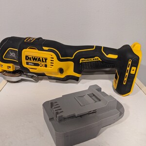 May include: A yellow and black DeWalt 20V XR cordless oscillating tool with a brushless motor and a gray battery charger.