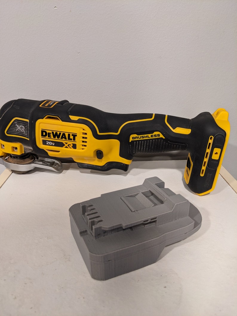 May include: A yellow and black DeWalt 20V XR cordless oscillating tool with a brushless motor and a gray battery charger.