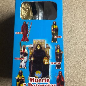 May include: A blue box labeled "NOVENARIO" with images of religious figures. The box features the words "Muerte 7 Potencias" and other Spanish words. The figures are in various colors, including red, yellow, and black.