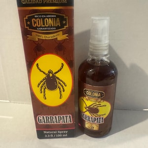 May include: A brown bottle and box of "GARRAPATA" natural spray cologne. The bottle contains a dark liquid and has a spray nozzle. The box and bottle feature a yellow circle with a tick illustration. The bottle is 3.3 fl oz / 100 ml.