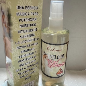 Może przedstawiać: Przezroczysta szklana butelka z rozpylaczem i pasujące pudełko z napisem "Colonia Velo de Novia". Butelka zawiera jasnoż&oacute;łty płyn. Pudełko zawiera hiszpański tekst i obraz panny młodej.