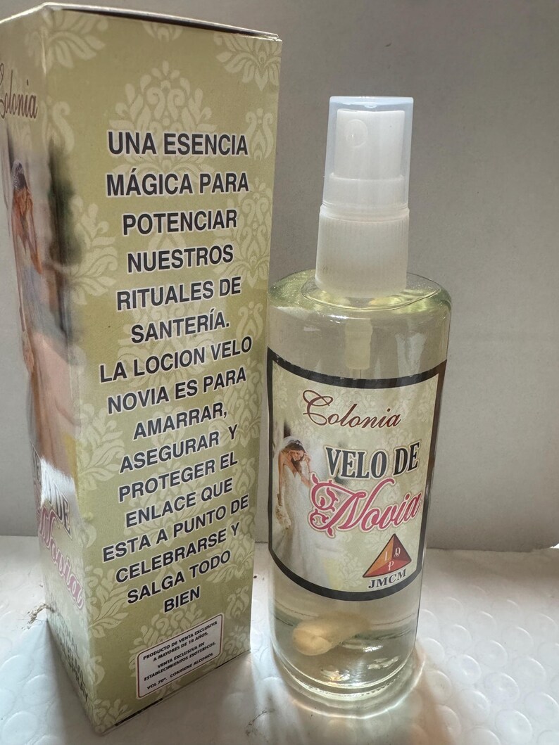 Może przedstawiać: Przezroczysta szklana butelka z rozpylaczem i pasujące pudełko z napisem "Colonia Velo de Novia". Butelka zawiera jasnoż&oacute;łty płyn. Pudełko zawiera hiszpański tekst i obraz panny młodej.