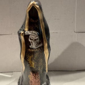 May include: A black Grim Reaper figurine with gold trim, a skull, and a copper-colored owl. The figurine is wrapped in clear plastic. The Reaper is holding a scythe.