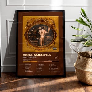 May include: A brown and gold album cover with the title "Cosa Nuestra" by Rauw Alejandro. The album cover features a couple in a romantic embrace. The album tracklist is listed on the right side of the cover.