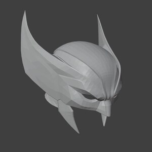 K&ouml;nnte beinhalten: Ein graues 3D-gedrucktes Modell eines Helms mit einem spitzen, kantigen Design. Der Helm hat zwei gro&szlig;e, spitze Ohren an den Seiten und einen spitzen Kinnschutz.