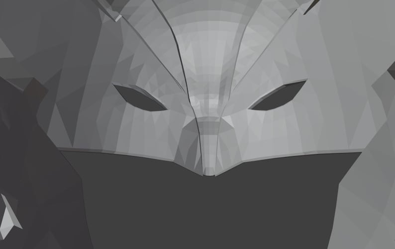 K&ouml;nnte beinhalten: Nahaufnahme einer grauen, geometrischen Maske mit zwei Augenl&ouml;chern. Die Maske besteht aus einem strukturierten Material und hat ein scharfes, kantiges Design.