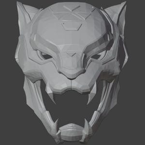 Può includere: Un modello 3D stampato in grigio di una maschera di animale stilizzata con un design angolare e affilato. La maschera ha una bocca spalancata con denti affilati e uno schema geometrico sulla fronte.