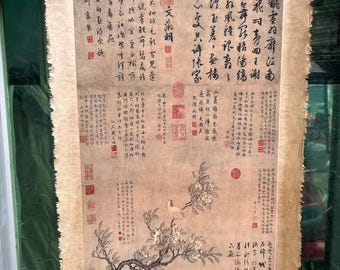 May include: Antique Chinese scroll featuring calligraphy and a painting of a flowering tree with birds. The artwork is on aged paper with a light brown hue, and includes red seals and intricate text. The scroll is held up by a person.