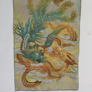 May include: A rectangular tapestry featuring a detailed embroidered design of a phoenix and a dragon. The phoenix is depicted with teal and green feathers, while the dragon is gold. The background is a pale yellow with clouds.