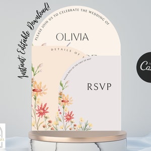 May include: A wedding invitation with a floral design. The invitation is in the shape of a half circle and has the text "Please join us to celebrate the wedding of Olivia" on the top half. The bottom half has the text "Details of" and "RSVP".
