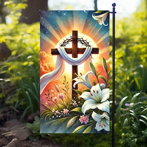 Pode incluir: Uma bandeira de jardim com uma cruz cristã cercada por lírios brancos e uma coroa de espinhos. A cruz está situada sobre um fundo de pôr do sol colorido com raios de luz brilhando para baixo.