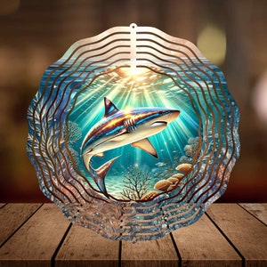 May include: A metal wind spinner with a colorful image of a shark swimming in the ocean. The spinner has multiple layers of metal that spin in the wind.
