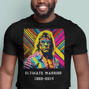 Może przedstawiać: Czarny T-shirt z kolorową grafiką Ultimate Warrior. Grafika przedstawia portret zapaśnika na kolorowym tle z paskami i kształtami geometrycznymi. Pod grafiką znajduje się napis "ULTIMATE WARRIOR 1959-2014".