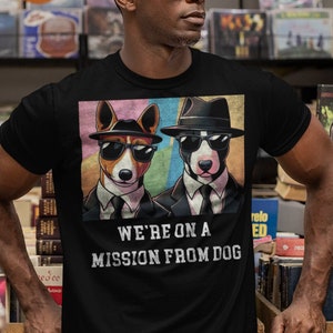 May include: A black t-shirt with a graphic of two dogs wearing sunglasses and fedoras. The text "We're on a mission from dog" is printed below the graphic.
