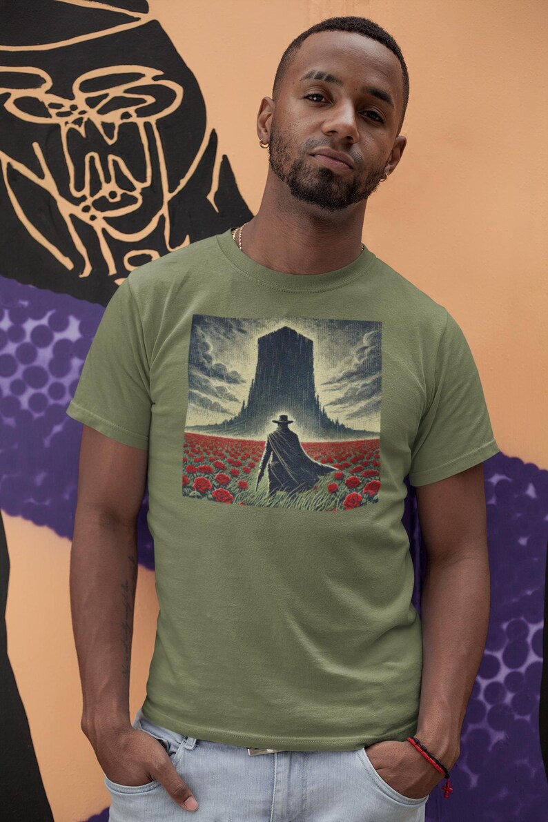 May include: A green t-shirt with a graphic print of a man in a black coat and hat walking towards a tall, dark building in a field of red flowers.