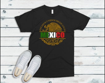 May include: Black t-shirt with a gold and green graphic of the Mexican coat of arms. The text "Estados Unidos Mexicanos" and "MEXICO" are printed in gold on the graphic.